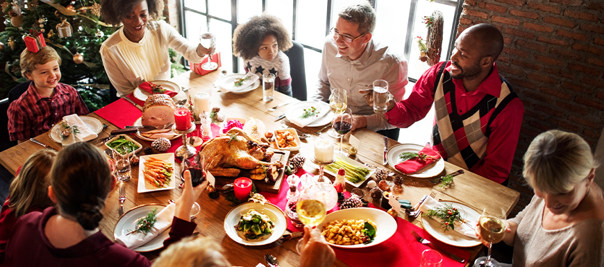 Family sitting around dinner table at Christmas